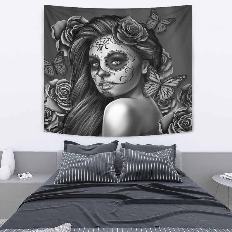 May include: Black and white tapestry featuring a woman with a sugar skull makeup design, surrounded by roses and butterflies.