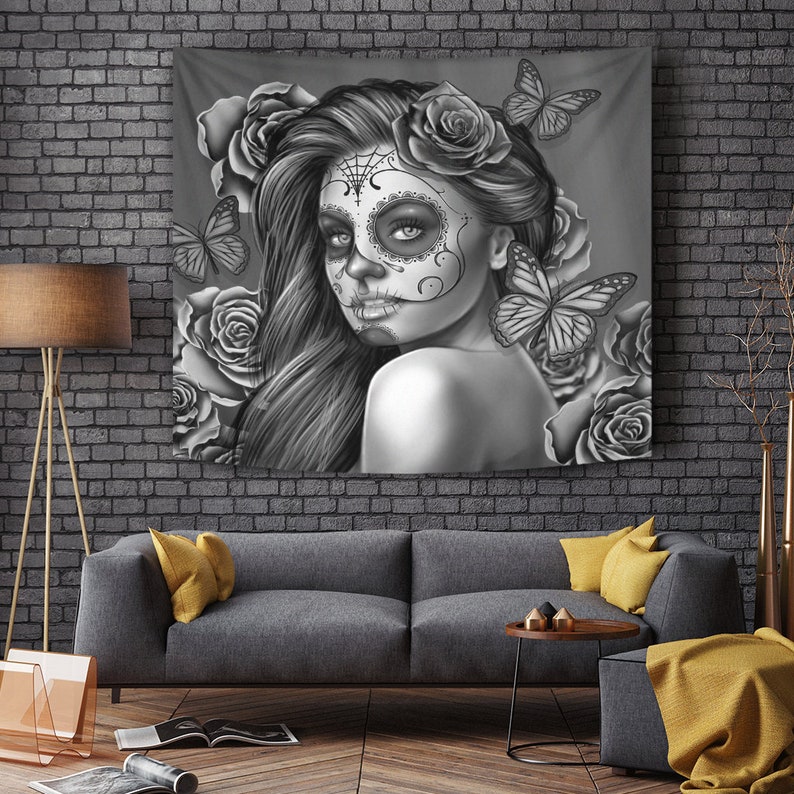 May include: Black and white tapestry featuring a woman with a sugar skull makeup design, surrounded by roses and butterflies.