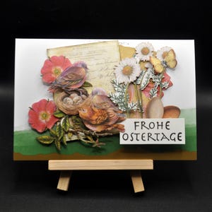 Handgemachte Osterkarte mit Vogelpaar im Nest, Frühlingsblüher mit Ostereiern auf grüner Wiese und gelben Schmetterling, Goldkante , Grün