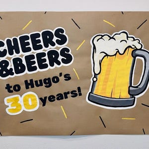 Puede incluir: Un letrero de papel marr&oacute;n con las palabras "CHEERS & BEERS" en negrita, en negro, y "to Hugo's 30 years!" en una fuente m&aacute;s peque&ntilde;a. Una jarra de cerveza de dibujos animados con espuma est&aacute; a la derecha, con detalles en amarillo y negro.