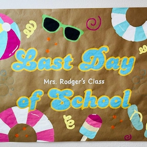 Puede incluir: Un letrero de papel marr&oacute;n con las palabras "Last Day of School" en azul y amarillo, con el texto "Mrs. Rodger's Class" debajo. El letrero est&aacute; decorado con im&aacute;genes de tem&aacute;tica playera como una pelota de playa, gafas de sol y un helado.