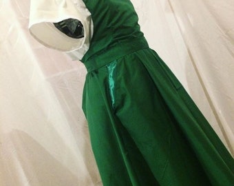May include: A green dress with a white collar and short sleeves. The dress has a fitted bodice and a full skirt.