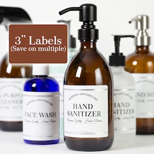 May include: Five amber glass bottles with pumps and labels. The labels are white with black text and say "Modern Apothecary" and "Hand Sanitizer", "Face Wash", "All-Purpose Cleaner", and "Hand Soap". The bottles are arranged in a row on a white surface. 3" Labels (Save on multiple)