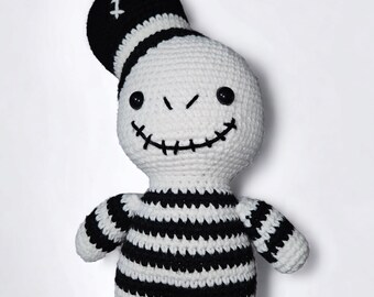Puede incluir: Muñeca de ganchillo hecha a mano con un diseño caprichoso. La muñeca presenta un cuerpo blanco con rayas negras, un sombrero de copa negro y una sonrisa cosida. Los ojos son botones negros. Los brazos y las piernas también son a rayas blancas y negras.