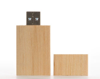 May include: A wooden USB flash drive with a silver USB connector. The drive is made of light brown wood and has a rectangular shape.