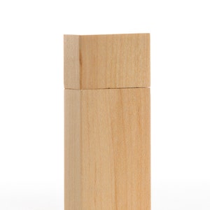 Puede incluir: Una memoria USB de madera con un acabado de madera natural.