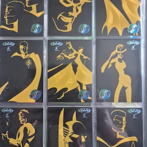Può includere: Nove carte collezionabili di Batman con illustrazioni dorate di personaggi su sfondi neri. Le carte mostrano Batman, Robin e l'Enigmista, con il logo "Metal Forever". Le carte sono in una custodia protettiva.