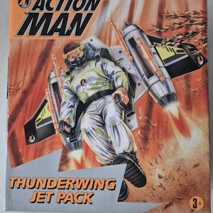 May include: Action Man Thunderwing Jet Pack toy packaging featuring a figure in a jet pack with orange and yellow accents. The packaging has a red and orange background with a 3+ age recommendation.