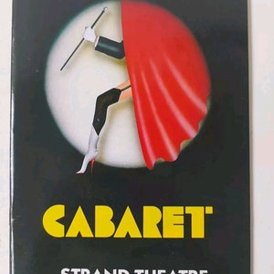 May include: A black and white poster featuring a red and white illustration of a woman in a cabaret setting. The poster reads "CABARET" in yellow letters and "STRAND THEATRE" in white letters.