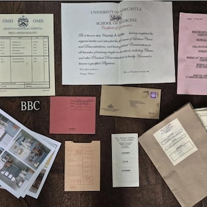 May include: A collection of vintage documents, including a medical school certificate, a BBC schedule, and hospital forms. The items are arranged on a dark wooden surface, with the BBC logo visible.