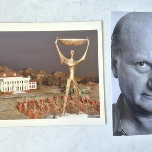 Puede incluir: Se muestran dos imágenes. Una es un retrato en blanco y negro de un hombre con pelo corto y camisa a rayas. La otra es una impresión en color de una estatua dorada sosteniendo un cuenco, con un edificio blanco y un paisaje al fondo.