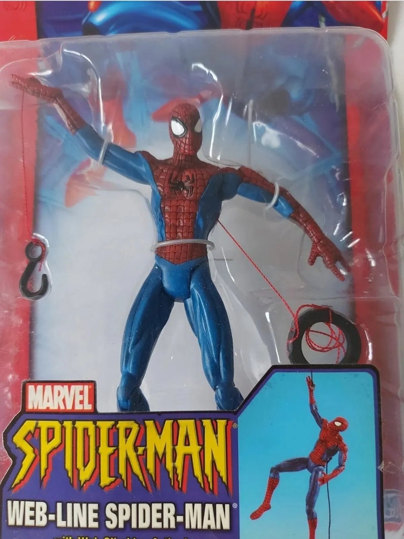 K&ouml;nnte beinhalten: Eine rote und blaue Spider-Man-Actionfigur mit einer Spinnwebenlinie, die an einem Reifen befestigt ist. Die Figur ist in einer Spinnweben-Schwing-Actionpose dargestellt. Die Verpackung zeigt das Marvel-Logo und den Text "Spider-Man Web-Line Spider-Man".