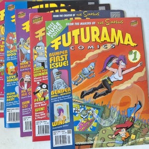 Puede incluir: Una pila de cómics de Futurama, con portadas vibrantes con personajes y texto. El cómic superior es el número 1, con una portada roja y amarilla. Se ven otros números, mostrando varios personajes y títulos.