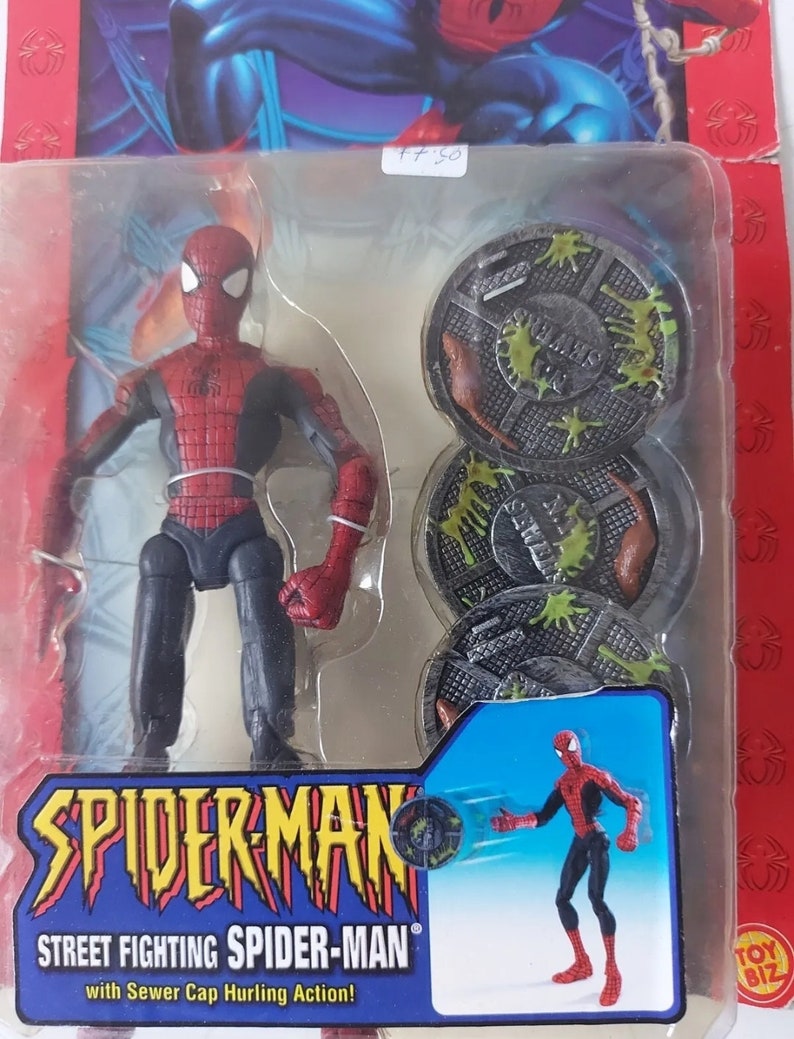Pode incluir: Uma figura de a&ccedil;&atilde;o do Homem-Aranha vermelha e azul com uma tampa de esgoto na m&atilde;o. A figura &eacute; embalada com tr&ecirc;s tampas de esgoto que t&ecirc;m limo verde nelas. A embalagem diz "Street Fighting Spider-Man with Sewer Cap Hurling Action!"