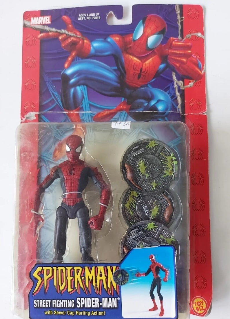 Pode incluir: Uma figura de a&ccedil;&atilde;o do Homem-Aranha vermelha e azul com a&ccedil;&atilde;o de arremesso de tampa de esgoto. A figura &eacute; embalada em uma embalagem blister de pl&aacute;stico com fundo vermelho e azul. A embalagem apresenta o logotipo da Marvel e o texto "Street Fighting Spider-Man".
