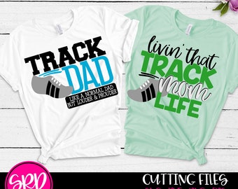 May include: Two white t-shirts with black and green text and a running shoe graphic. The text on the white shirt reads "Track Dad" and "Like a normal dad but louder & prouder". The text on the green shirt reads "Livin' that Track Mom Life".