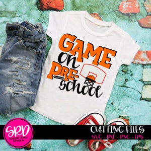 May include: Orange and black graphic design on a white t-shirt that says "Game on Pre-School" with a basketball going through a hoop.