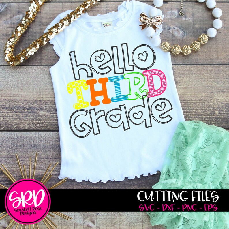 May include: A white t-shirt with the text "hello third grade" in colorful letters with a patterned design. The letters are outlined in black. The shirt has a ruffled hem.