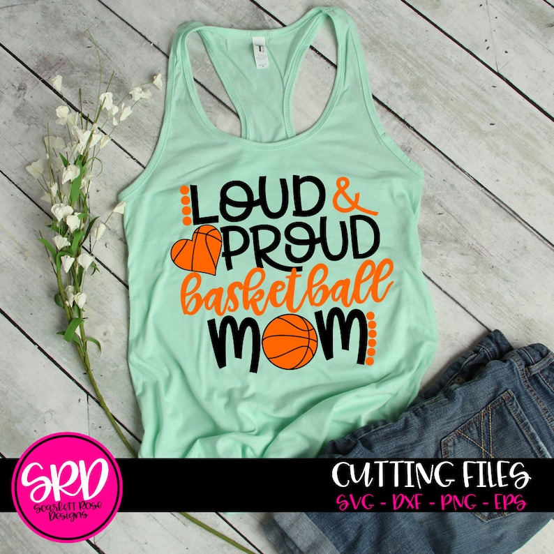 May include: A light green tank top with the text "Loud & Proud Basketball Mom" in black and orange. A basketball and a heart are included in the design.