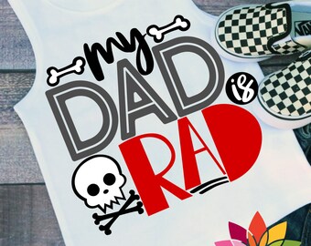 May include: White sleeveless shirt with the text "my DAD is RAD" in black, gray, and red. A skull and crossbones graphic is below the text.