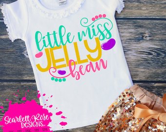 May include: White t-shirt with a pink, yellow, and green design that says "little miss jelly bean".