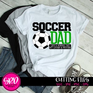 May include: White t-shirt with a green and black design that says "Soccer Dad" with a soccer ball graphic and the text "Like a normal dad but louder & prouder".