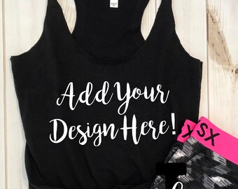 Puede incluir: Una camiseta sin mangas negra con el texto "Add Your Design Here!" en escritura blanca. La camiseta sin mangas está anudada en la parte inferior. Un par de leggings con estampado en blanco y negro con una cintura rosa están al lado. La palabra "mockups" también está en la imagen.