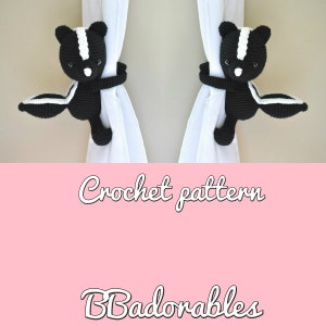 Op de afbeelding: Twee zwarte en witte gehaakte stinkdier gordijnbinders die aan witte gordijnen hangen. De tekst "Crochet pattern" en "BBadorables" is onder de gordijnbinders gedrukt.