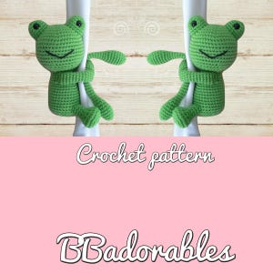 May include: Crochet pattern for a green frog amigurumi toy. The frog is holding onto a white pole with its arms and legs. The pattern is called "Badorables".