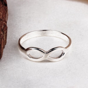 May include: A silver infinity ring with a smooth, polished finish.