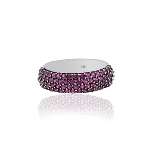 May include: A silver band ring with a row of pink gemstones. The ring is marked with the number 925.