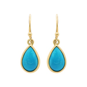 May include: A pair of gold teardrop earrings with turquoise stones.