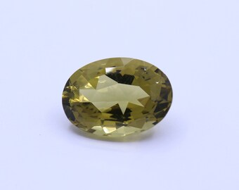 Puede incluir: Una piedra preciosa ovalada de color verde claro con un corte facetado.