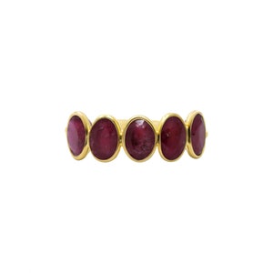 May include: A gold ring with five oval-shaped red gemstones.
