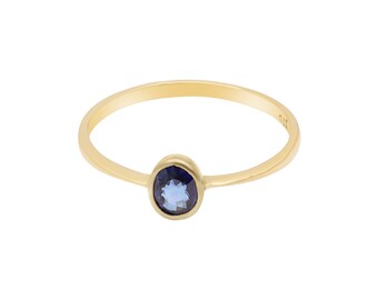 Puede incluir: Un anillo de oro con una piedra preciosa azul. El anillo es simple y elegante.