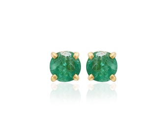May include: A pair of gold stud earrings with emerald green gemstones.