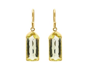 Puede incluir: Un par de pendientes de oro con gotas de piedras preciosas verde claro. Los pendientes tienen un diseño sencillo y son perfectos para el uso diario.