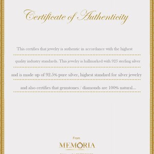 Peut inclure: Un certificat d'authenticit&eacute; avec une bordure dor&eacute;e et du texte. Le certificat indique que le bijou est authentique, poin&ccedil;onn&eacute; avec de l'argent sterling 925, compos&eacute; &agrave; 92,5 % d'argent pur et que les pierres pr&eacute;cieuses/diamants sont 100 % naturels. Le logo Memoria et les coordonn&eacute;es sont en bas.