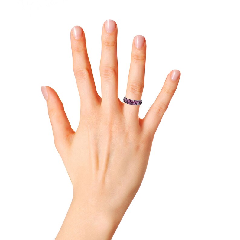 May include: A silver band ring with a row of small pink gemstones.