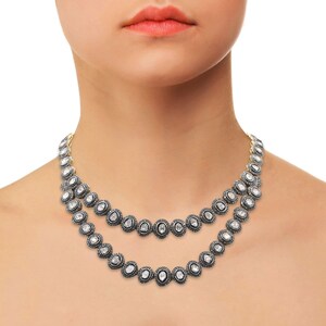 May include: A double-strand necklace featuring oval-shaped diamonds set in silver. The necklace is crafted from small, round diamonds that are set in a silver frame. The necklace is a classic and elegant piece of jewellery.