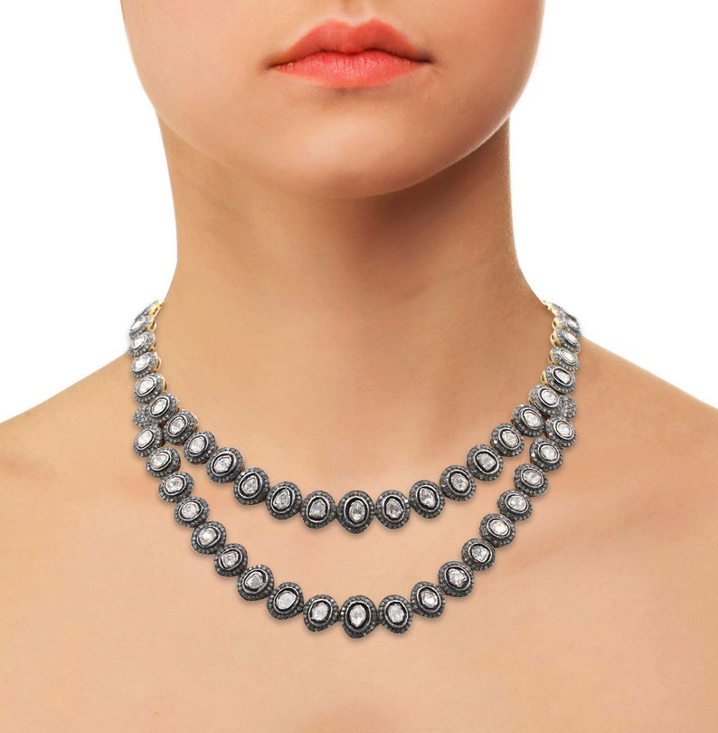 May include: A double-strand necklace featuring oval-shaped diamonds set in silver. The necklace is crafted from small, round diamonds that are set in a silver frame. The necklace is a classic and elegant piece of jewellery.