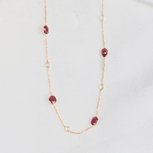 Puede incluir: Un collar de cadena de oro con piedras preciosas rojas ovaladas y piedras preciosas redondas transparentes alternadas.