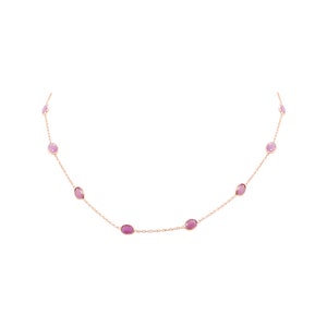 Puede incluir: Un delicado collar de cadena dorada con piedras preciosas rosas de forma ovalada. El collar tiene un diseño sencillo y es perfecto para el uso diario.