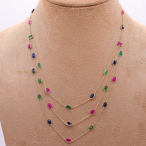 Collar multicapa en oro de 18 quilates, rubíes, zafiros y esmeraldas.