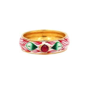 Op de afbeelding: Een gouden ring met een witte band met rode en groene bloemmotieven. Een kleine, ronde, rode edelsteen is in het midden van de ring gezet. De ring heeft een gepolijst gouden interieur.