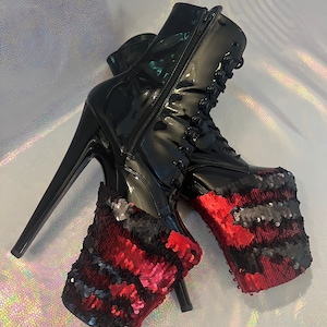 May include: Black patent leather platform boots with red and black sequin platform covers. The boots have a lace-up front and a zipper on the back.