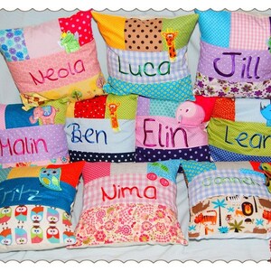 May include: Ten colorful patchwork pillow covers with different embroidered names, including Neda, Luca, Jill, Halin, Ben, Elin, Lean, Fritz, Nima, and Janne. Each pillow cover features a unique design with various fabrics and appliques.