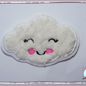 Könnte beinhalten: Eine weiße, flauschige Wolke mit einem lächelnden Gesicht und rosa Wangen. Die Wolke ist mit einem einfachen Lächeln und zwei rosa Kreisen für die Wangen bestickt.