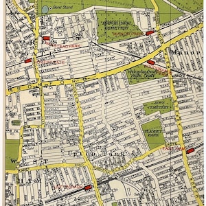 Puede incluir: Una impresión enmarcada de un mapa antiguo que muestra un mapa de calles detallado, con el texto "WANSTEAD FLATS" y "CITY OF LONDON CEMETERY". El mapa tiene un fondo crema con líneas negras y amarillas, y áreas verdes. La impresión está en un marco blanco.
