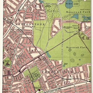 Op de afbeelding: Een vintage-stijl kaartafdruk van de gebieden Leytonstone, Wanstead Park en Forest Gate in Londen, met roze woonblokken, groene parken en blauwe waterpartijen, gepresenteerd in een witte rechthoekige passe-partout.